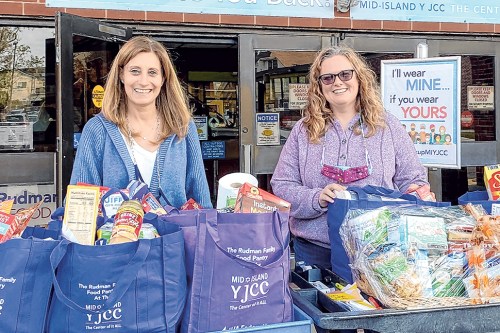 Gail Warrack, the director of Volunteer Services and The Rudman Family Food Pantry 
at The Mid Island Y-JCC, and Fran O’Conner, the president of Jericho Cares, provide 
Thanksgiving Baskets to families. (Photo courtesy Jericho Cares)