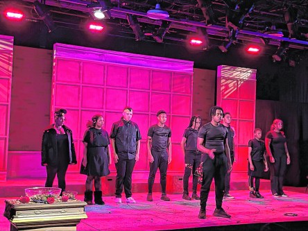 Performers raise their fists during rehearsal for What To Send Up When It Goes Down at Nassau Community College. (Credit: Danielle Criss)
