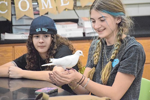 SCHOOLS_animals_021424_A Locust Valley High School student Mary Tockman (left) watches as Amber Prisco (right) holds onto the dove that Ranger Eric Powers brought for members of the school’s Animal and Environmental Awareness Club to meet on Jan. 18.
(Photos courtesy the Locust Valley Central School District)