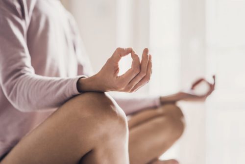 Woman meditating at home. Girl practicing yoga in yoga class (Getty Images)