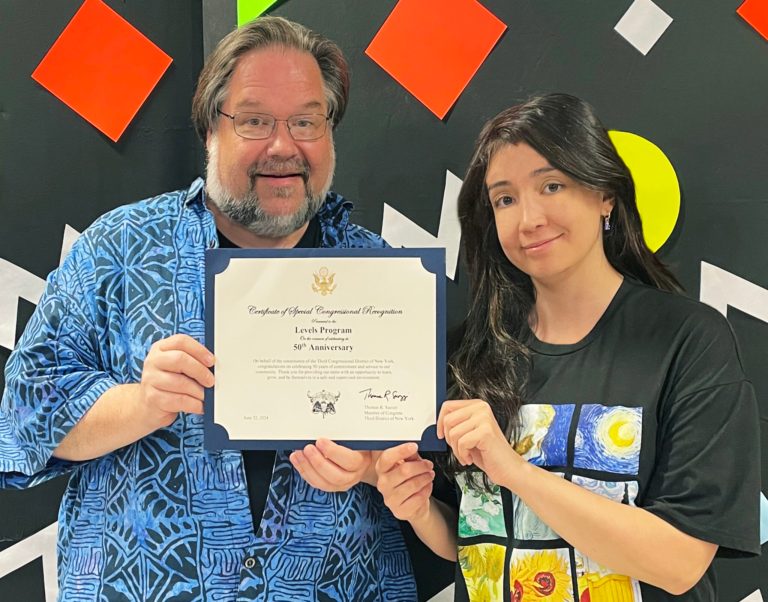 Levels Manager Barry Weil (L) and Assistant Manager Samantha Zahabian (R) display a commendation from Congressman Thomas R. Suozzi for Levels’ 50 years of service to the community. (Photos by the Great Neck Library)