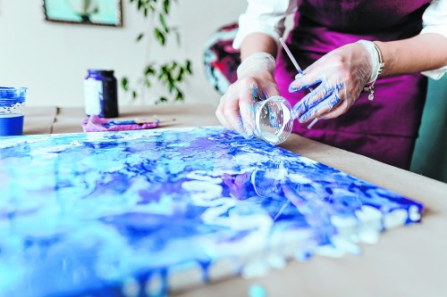 Artist mixing acryl paints on the picture working in fluid art technique Join a couples art class on Friday, Sept. 27 (Getty Images)