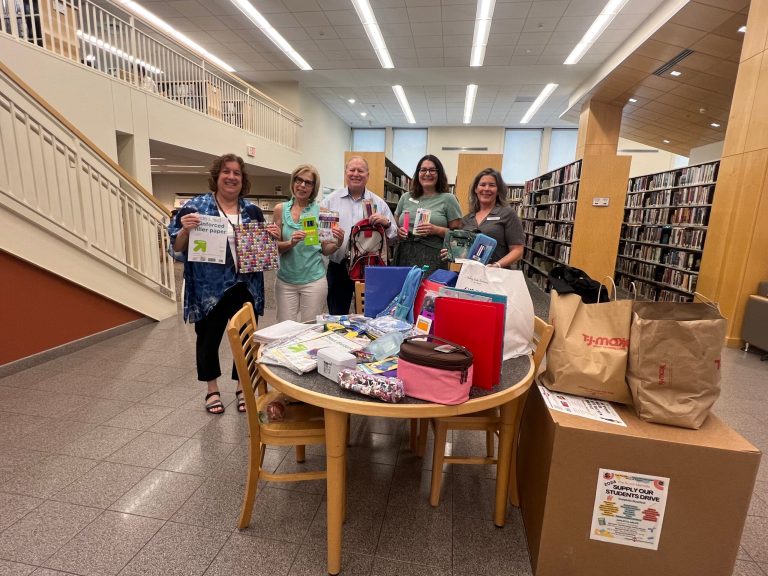 From left, Syosset Public Library Director Christine Belling, Assistant Director Sharon Long, Deputy Minority Leader Drucker, Head of Adult Programming Alisa Fogel and Programming & Arts Librarian Pam Strudler pictured with donations on Wednesday, July 17. (Photo credit: Office of Deputy Minority Leader Arnold W. Drucker)