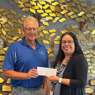 Robert Brull (left), president of the Marilyn Lichtman Foundation presents Aimee Keegan, ACLD
chief development and marketing officer a check to benefit the Generator Campaign. (Photo courtesy of ACLD)